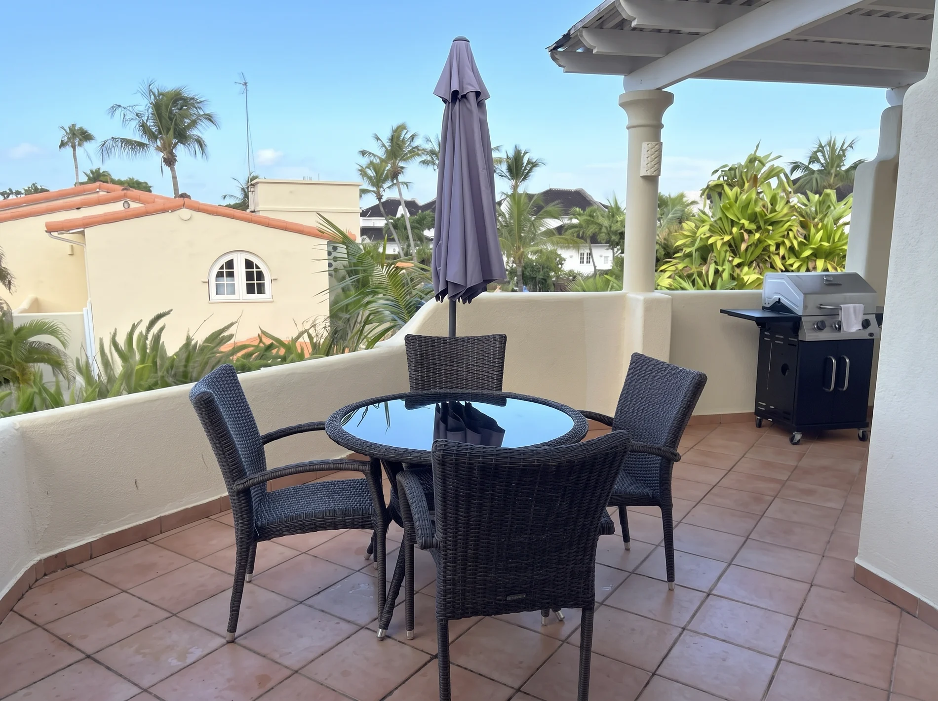 Upper terrace with dining table and barbecue at Palm Breeze Villa