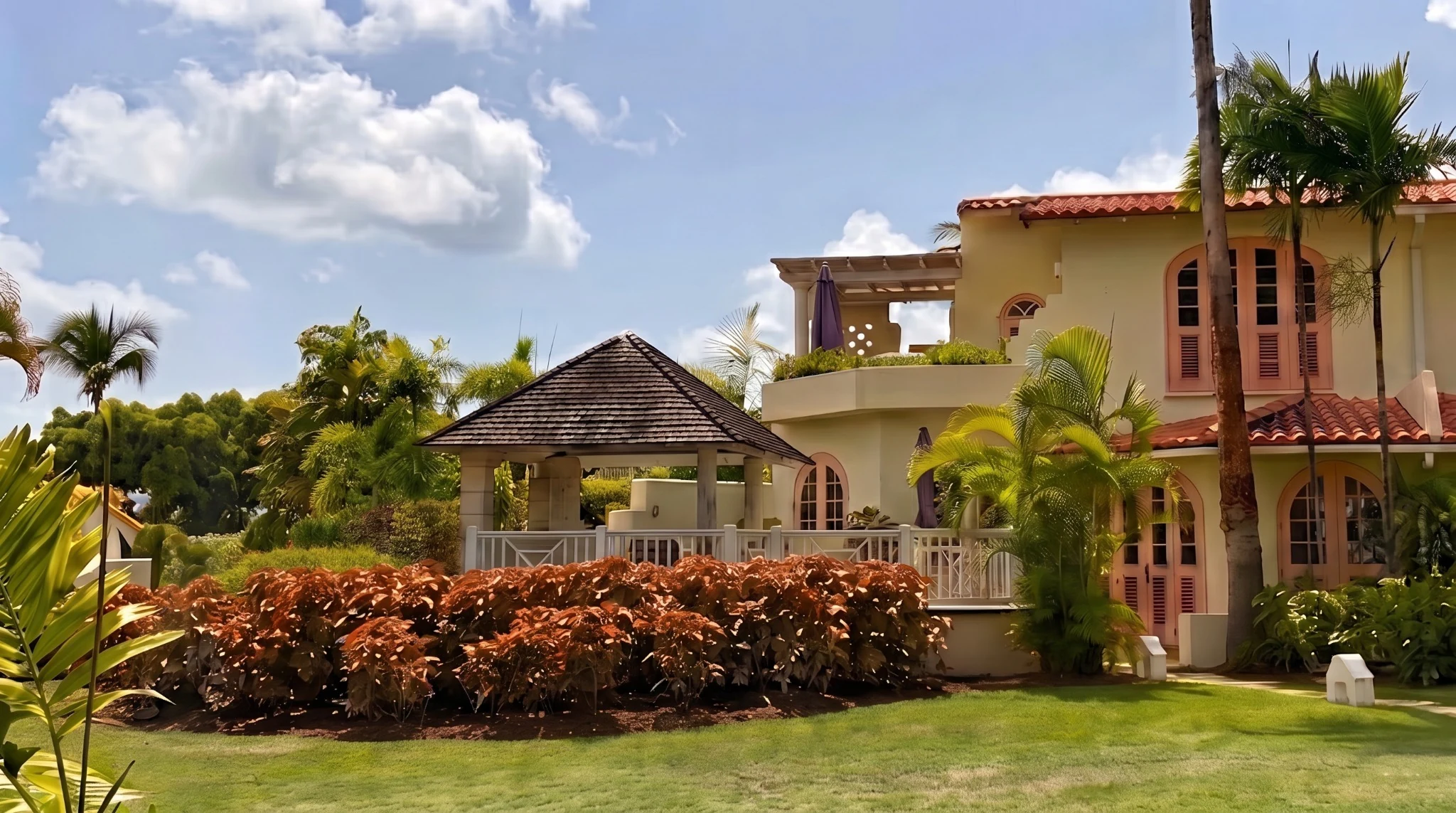 Rear garden of Palm Breeze Villa with gazebo, tropical planting and villa façade